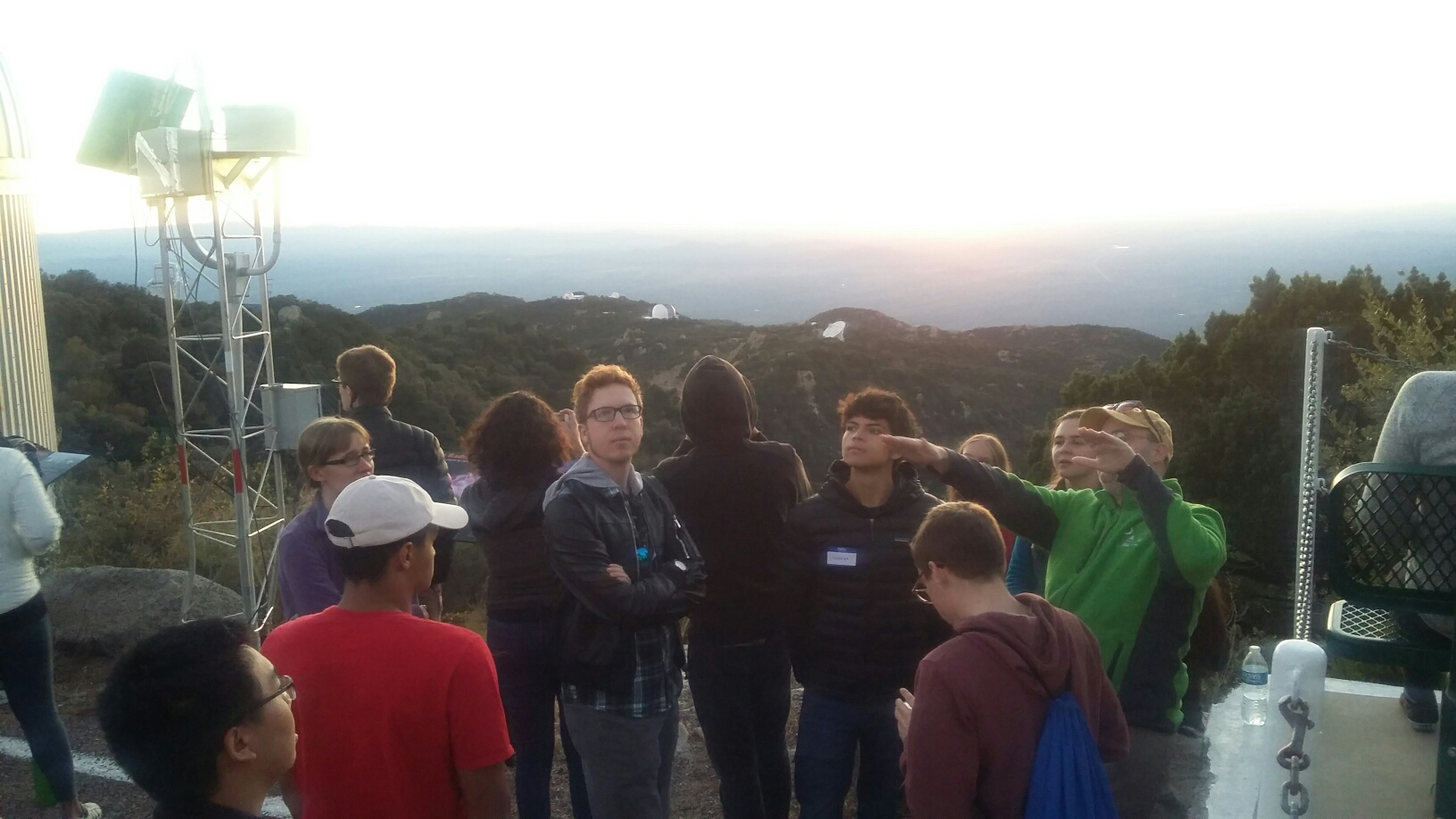 Group of club members and interns mingles in front of Kitt Peak Observatory telescope.