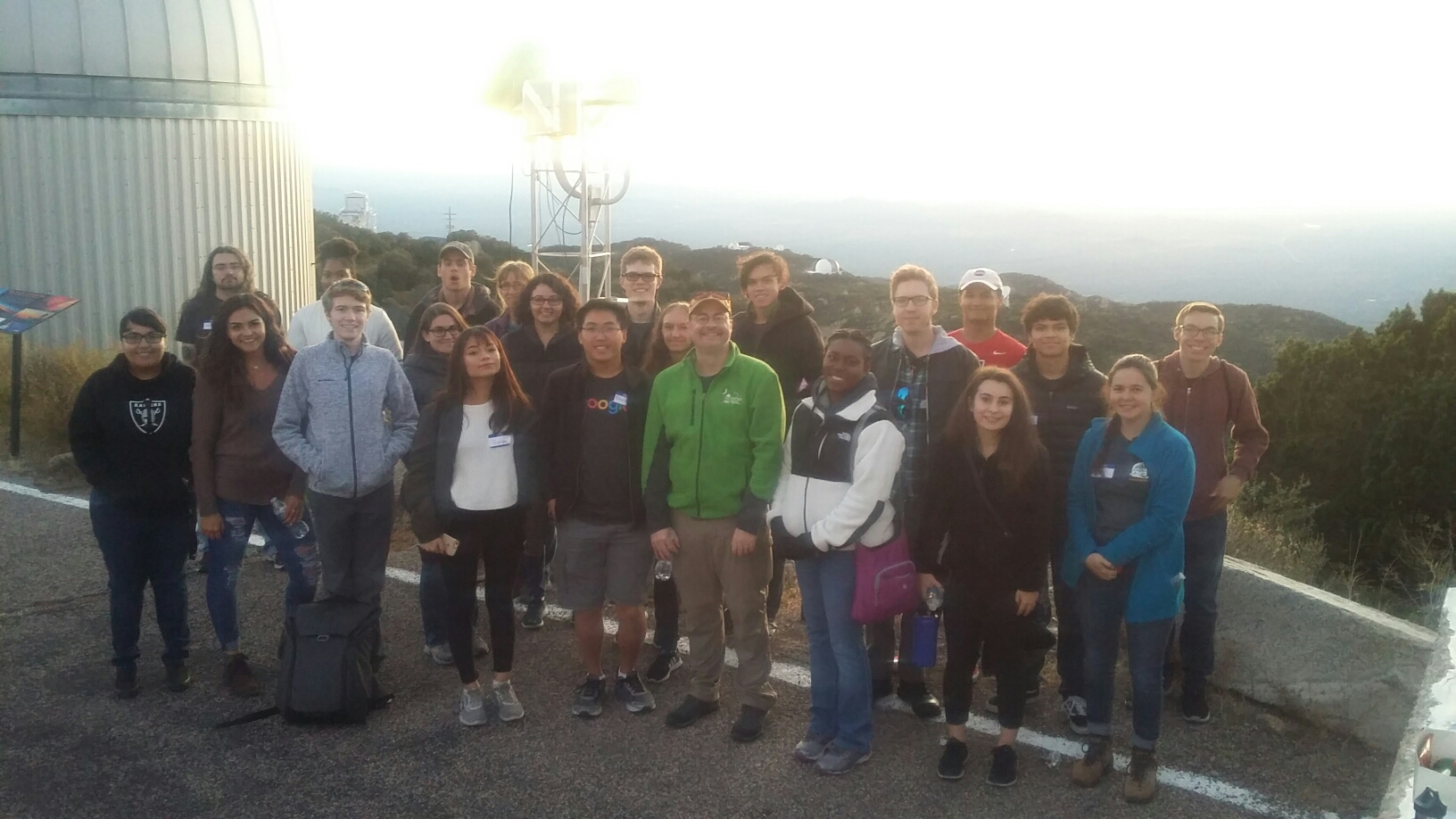 Group of club members and interns poses in front of Kitt Peak Observatory telescope.