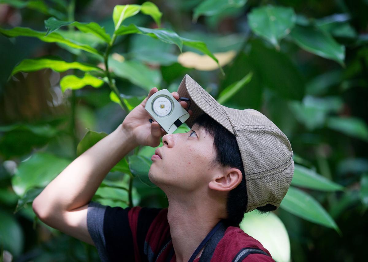 Hiroaki Sato takes a measurement inside the tropical rain forest at Biosphere 2.
