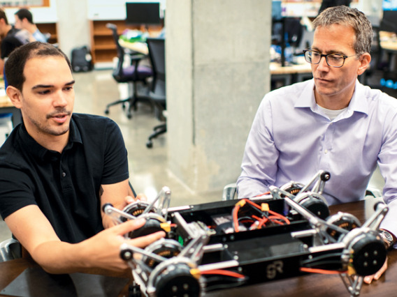 Todd Murphey working on robotics with student.