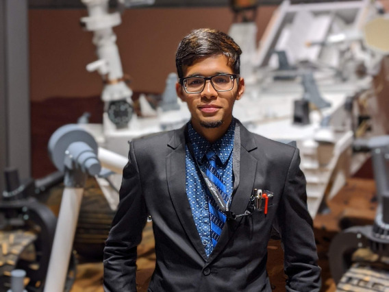 Arsh Nadkarni stands in front of rover model