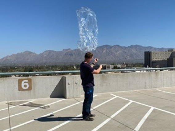 Student, Josh Crest, launchs pico balloon from rooftop. 