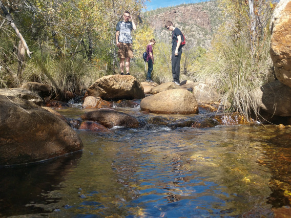 Space Grant students stand on boulders in a creek at Seven Falls, AZ.