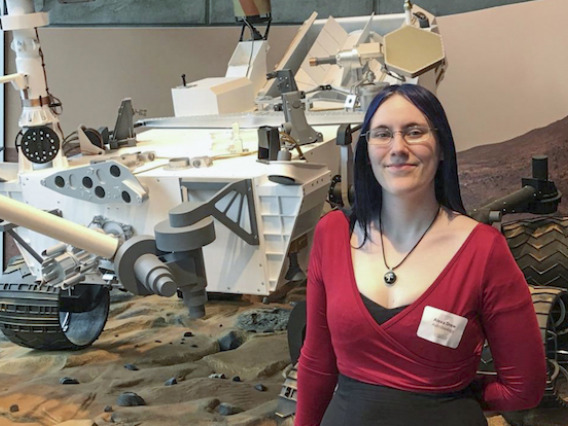 Alexa Drew poses in front of rover model