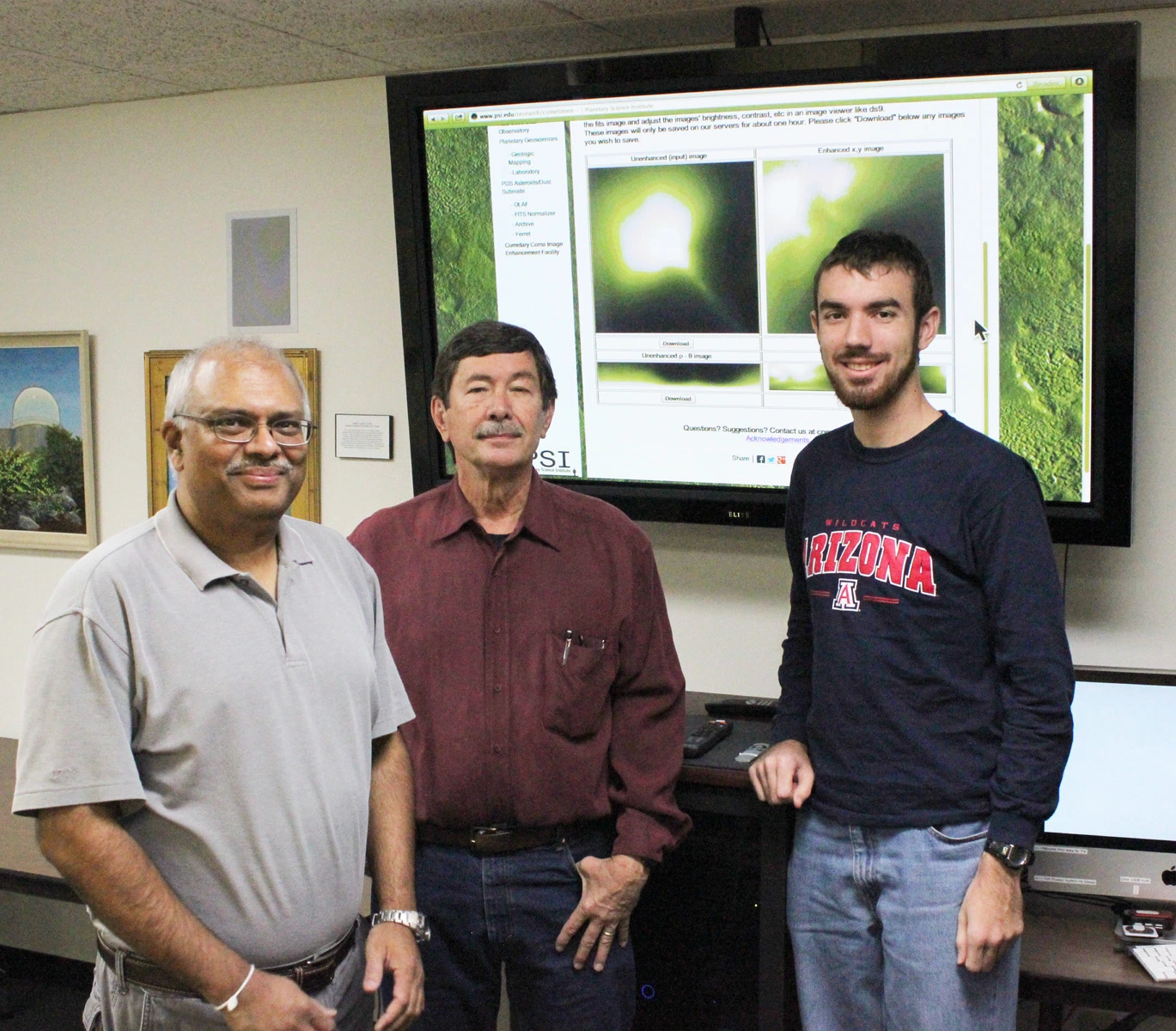 N.H. Samarasinha, S.M. Larson, and M.P. Martin (left to right) in front of a display showing the results from the web facility.