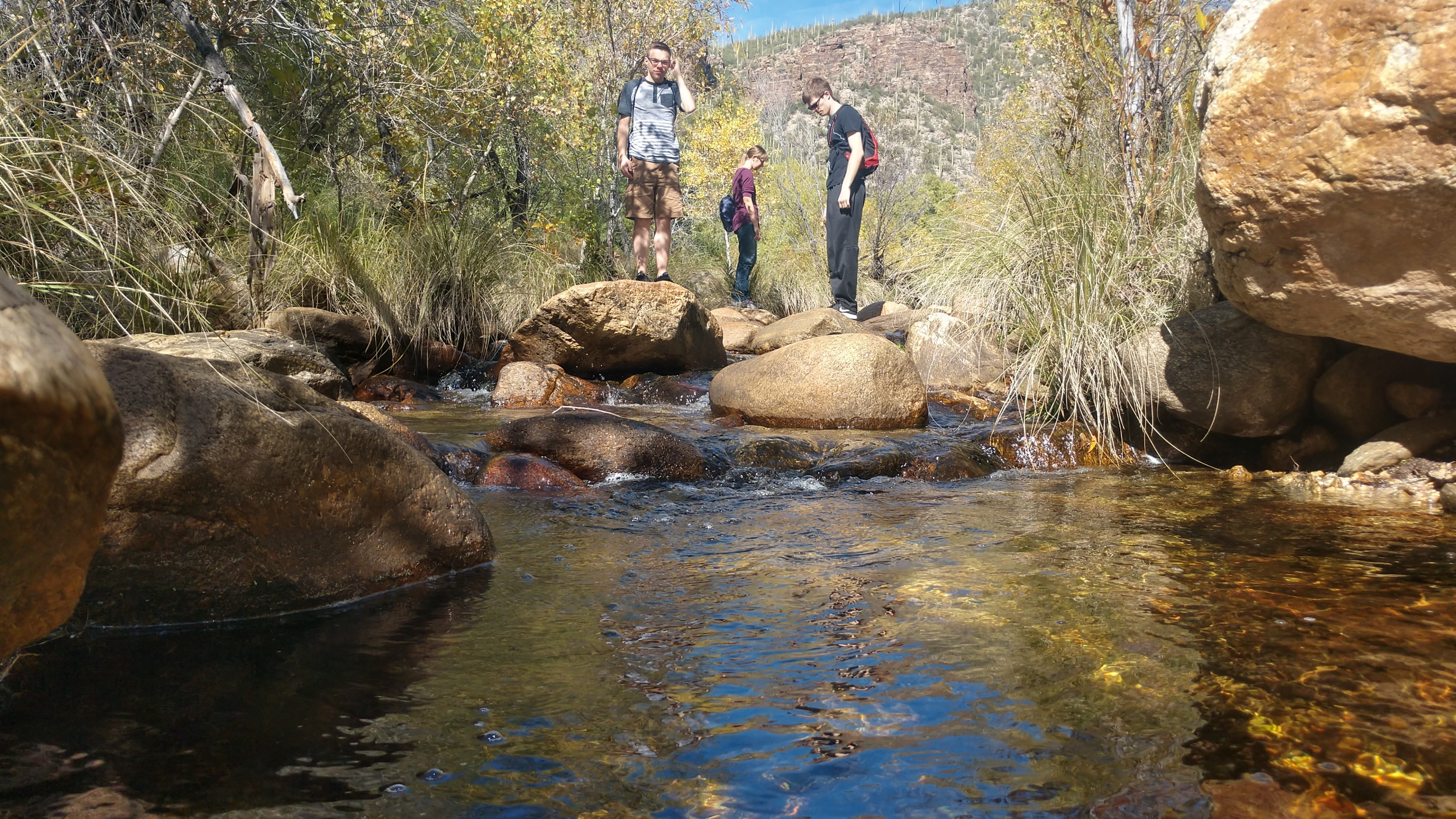 Space Grant students stand on boulders in a creek at Seven Falls, AZ.