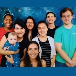 Cathryn Sephus, top left, and Betul Kacar, second from left, pose with members of the Kacar Lab. Betul Kacar holds her child.