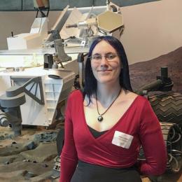 Alexa Drew poses in front of rover model